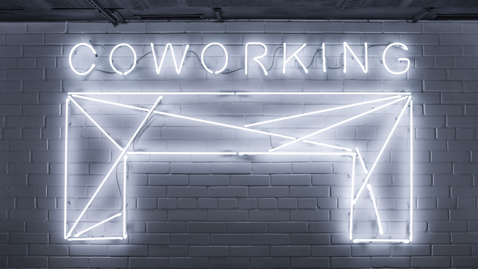 a Neon sign that says “Coworking”. 
