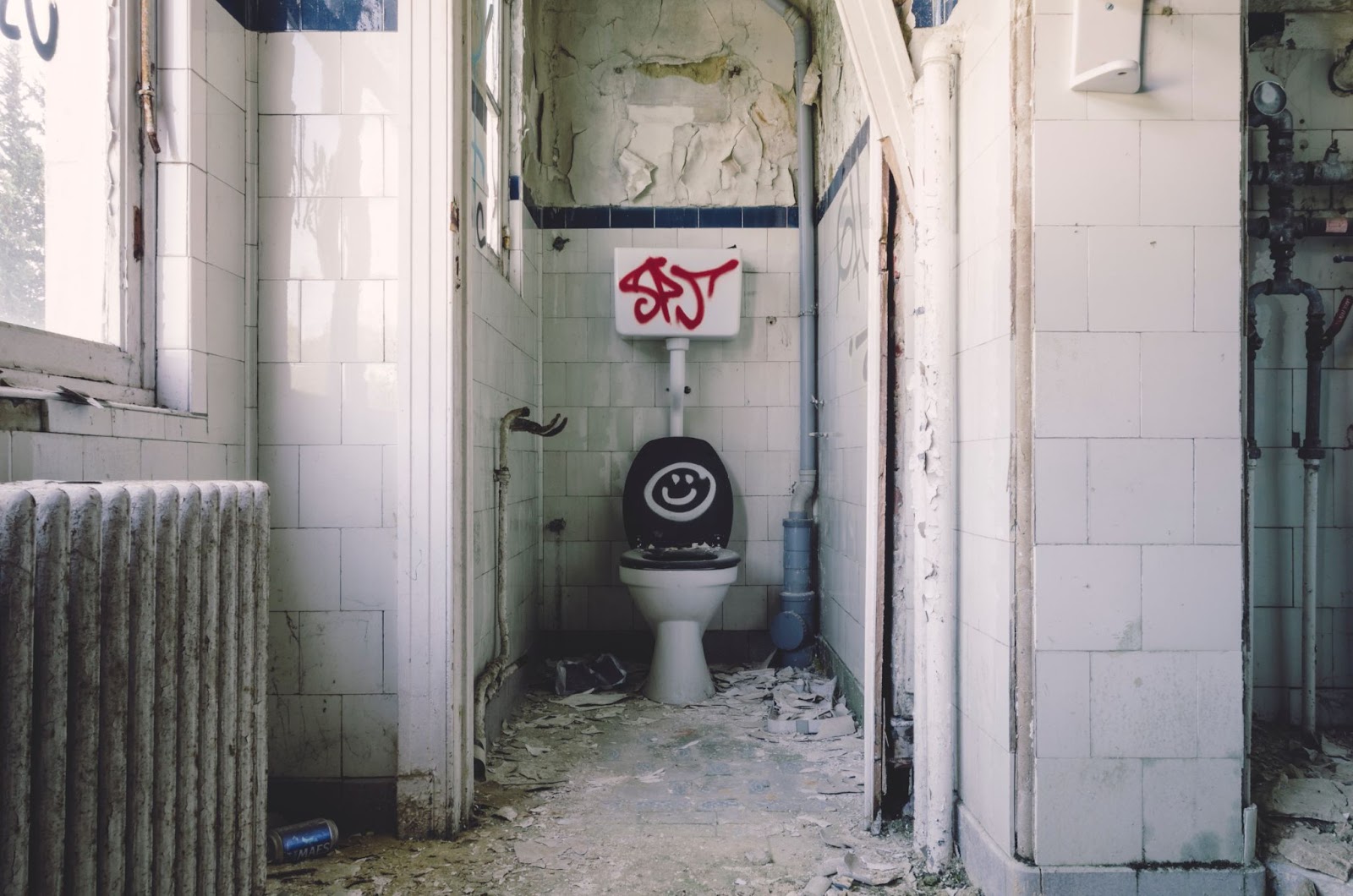 A bathroom with a smiley face painted on the toilet seat
