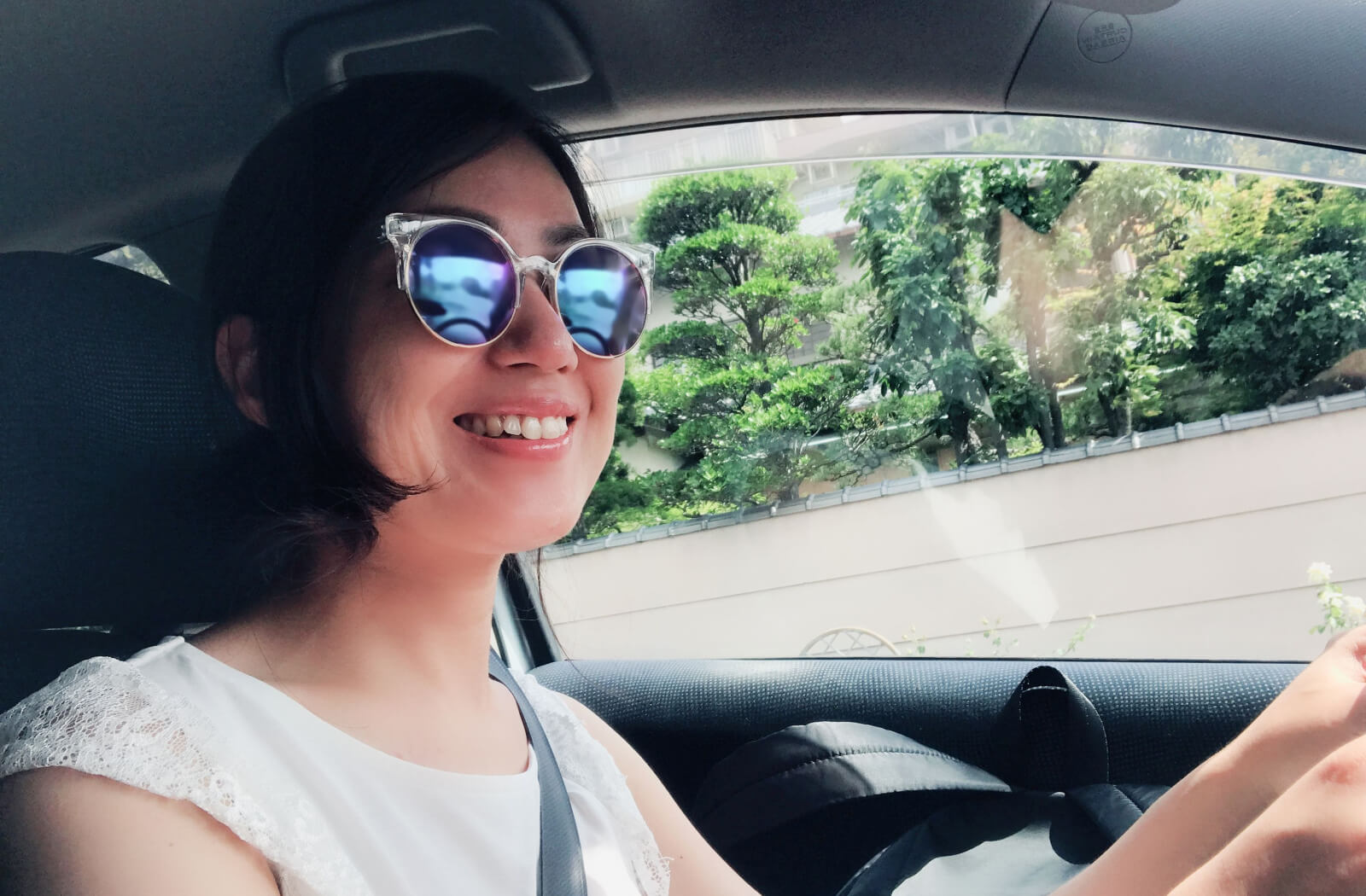 A woman is wearing polarized sunglasses to block glare for safer driving conditions.