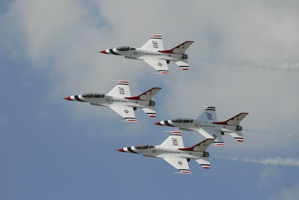 four white jet planes flying during daytime