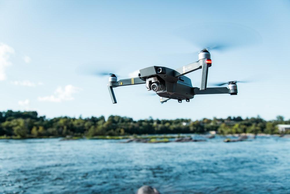 black DJI Mavi quadcopter near body of water