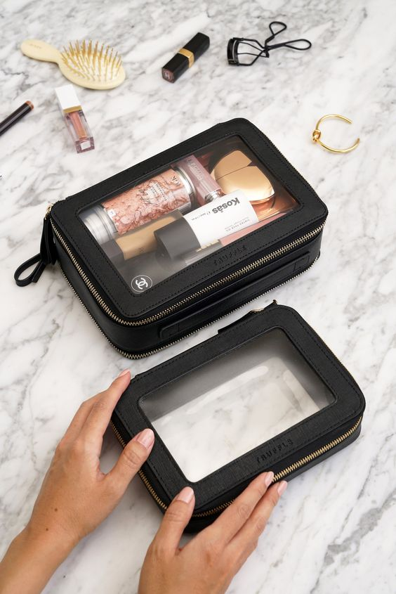 a lady's hands holding some travel makeup essentialsd