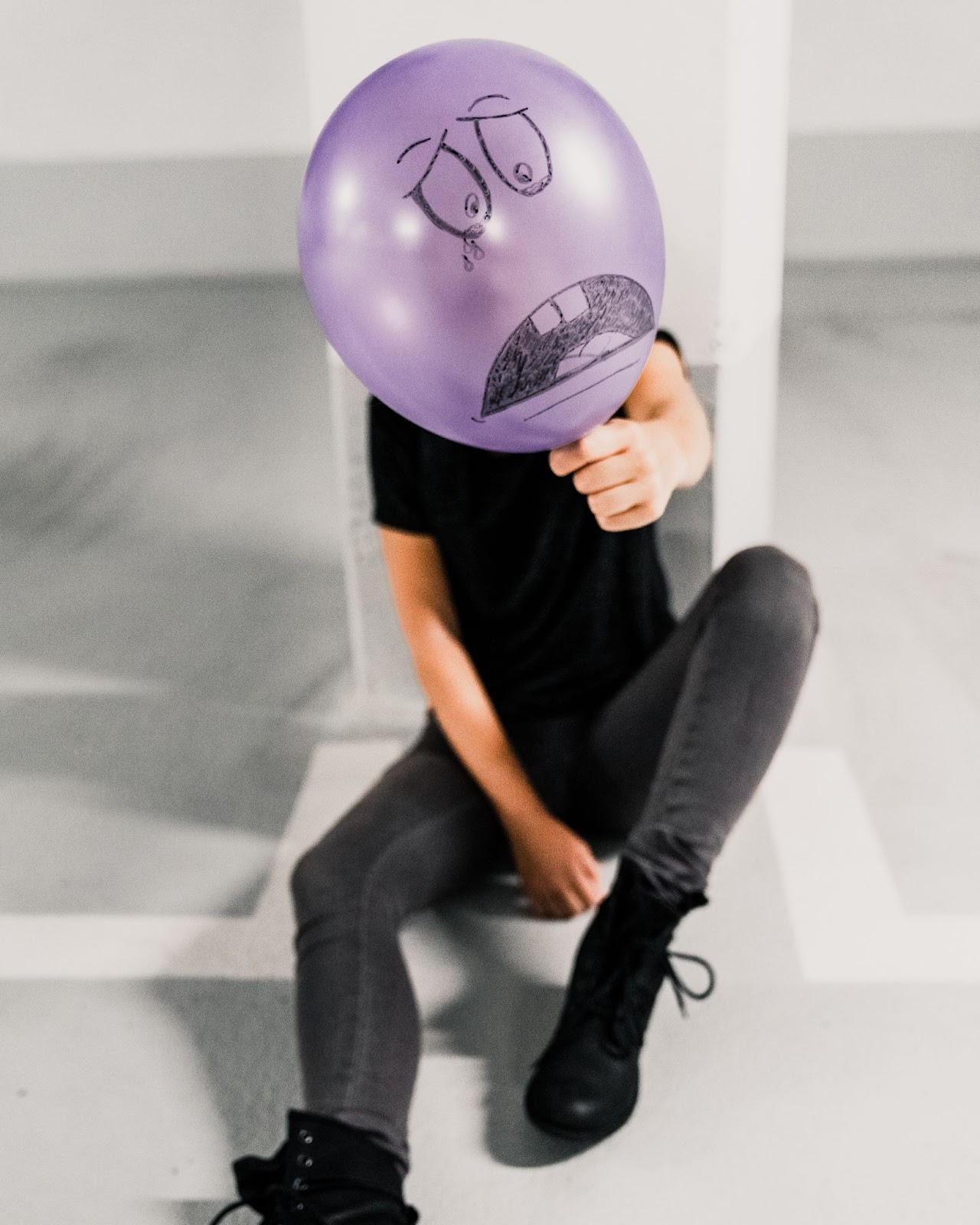 A person holding a sad balloon