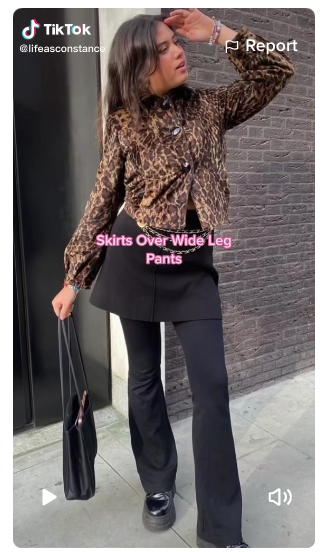 mobile screenshot of a lady layering black skirt over black pants in a TikTok video