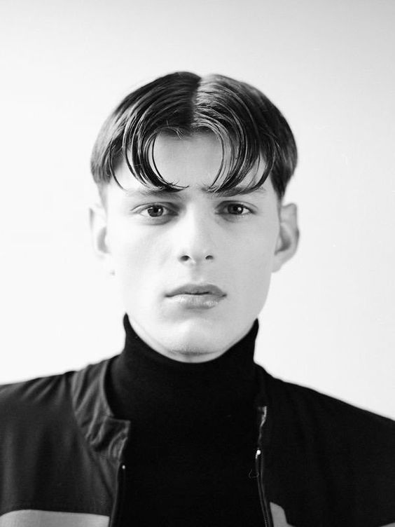 Black and white picture of  a guy rocking the  blunt cut middle  part