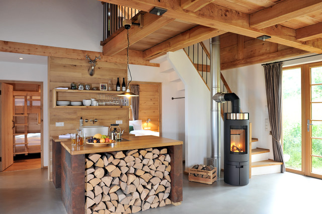 rustic wood cabin with miniature kitchen in the center of the home. wood open shelving and a wooden center island tie the kitchen in with the rest of the home's finishes