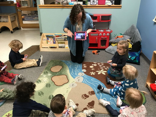 A teacher shows toddlers a video of a Japanese tea ceremony.  
