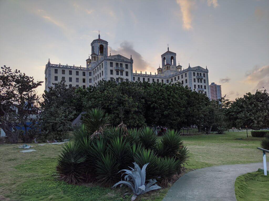 A large white building with a fountain in front of it

Description automatically generated with low confidence