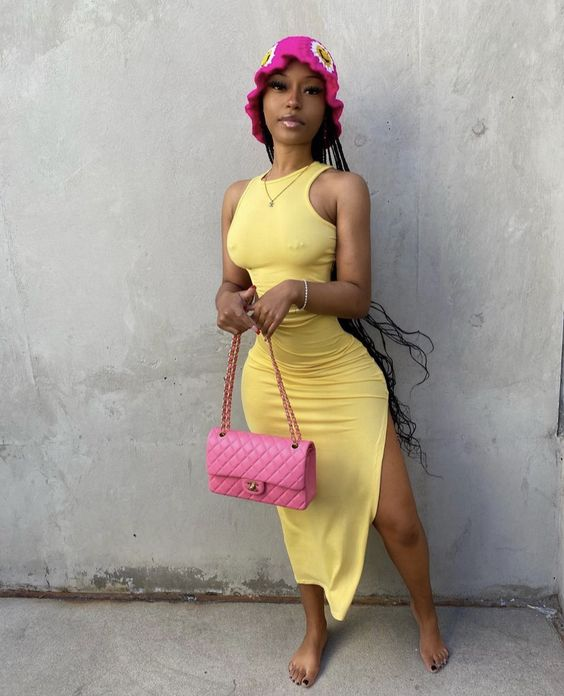 lady wearing bucket hat with yellow dress and pink handbag