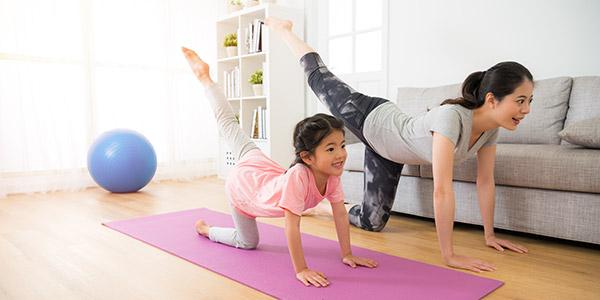 Asian mother and daughter doing yoga together.