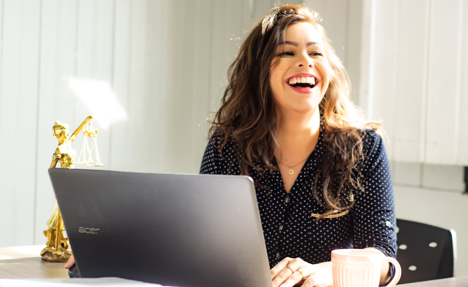 woman laughing in front of laptop