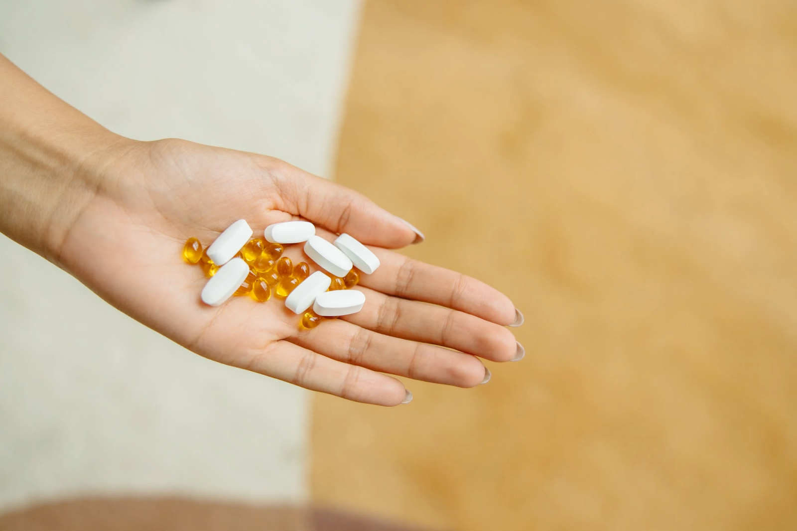 A hand holding vitamin supplements