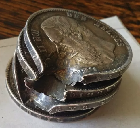 The bullet-damaged change, stacked in the order in which it was shot.