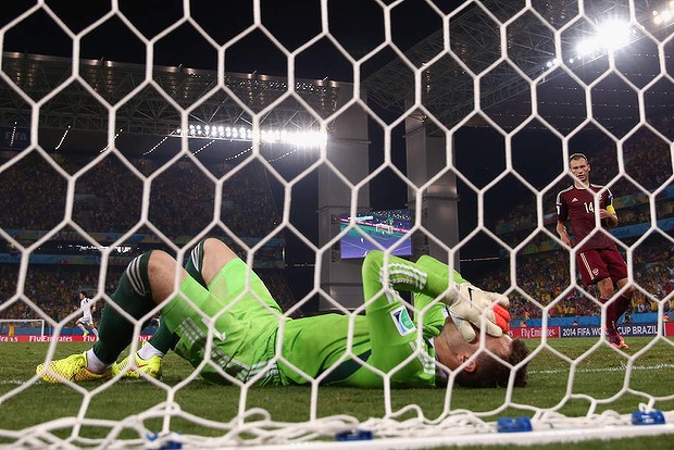 Igor Akinfeev of Russia lies in the net after failing to save a shot.