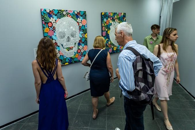 A group of people looking at art  Description automatically generated