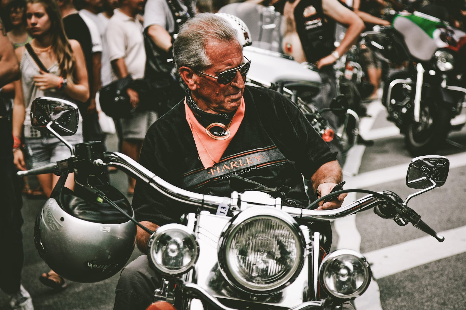 An old man posing on his motorbike. You can keep riding motorbikes even in old age until you feel your body is resisting or unable to cope up. 