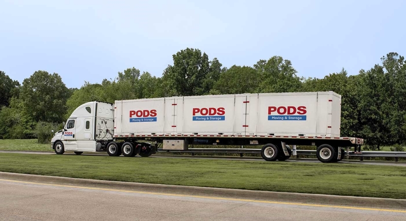 A flatbed truck transporting PODS moving containers.