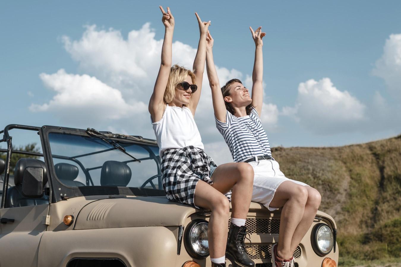 Two women sitting on a car

Description automatically generated with medium confidence