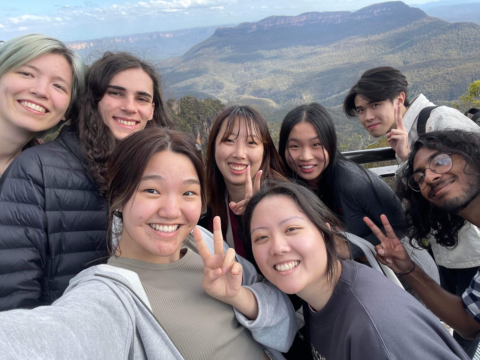 A group of students smile at the camera with mountains in the background!