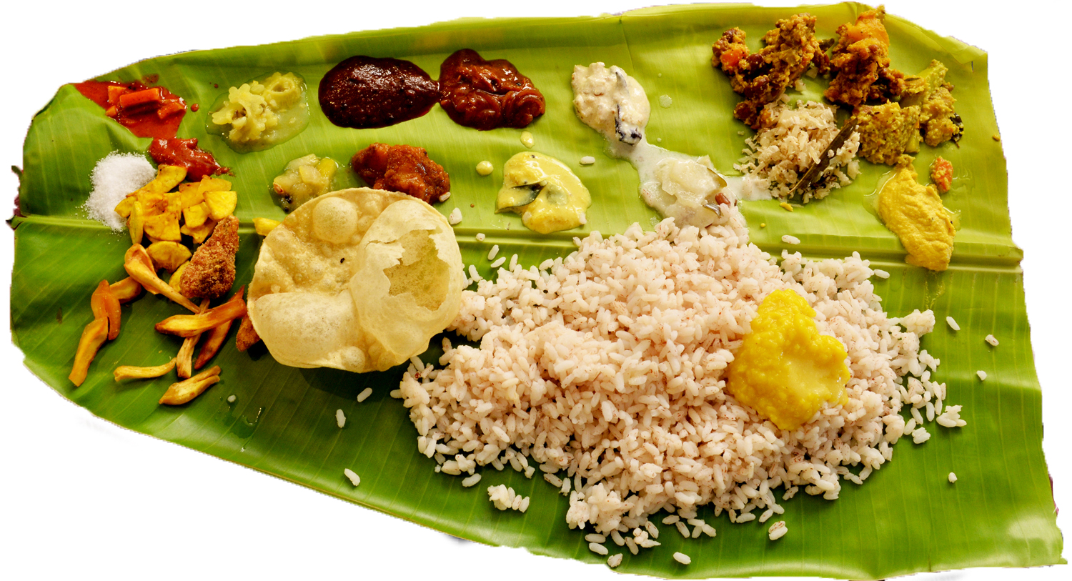 various foods and spices laid out on a banana leaf