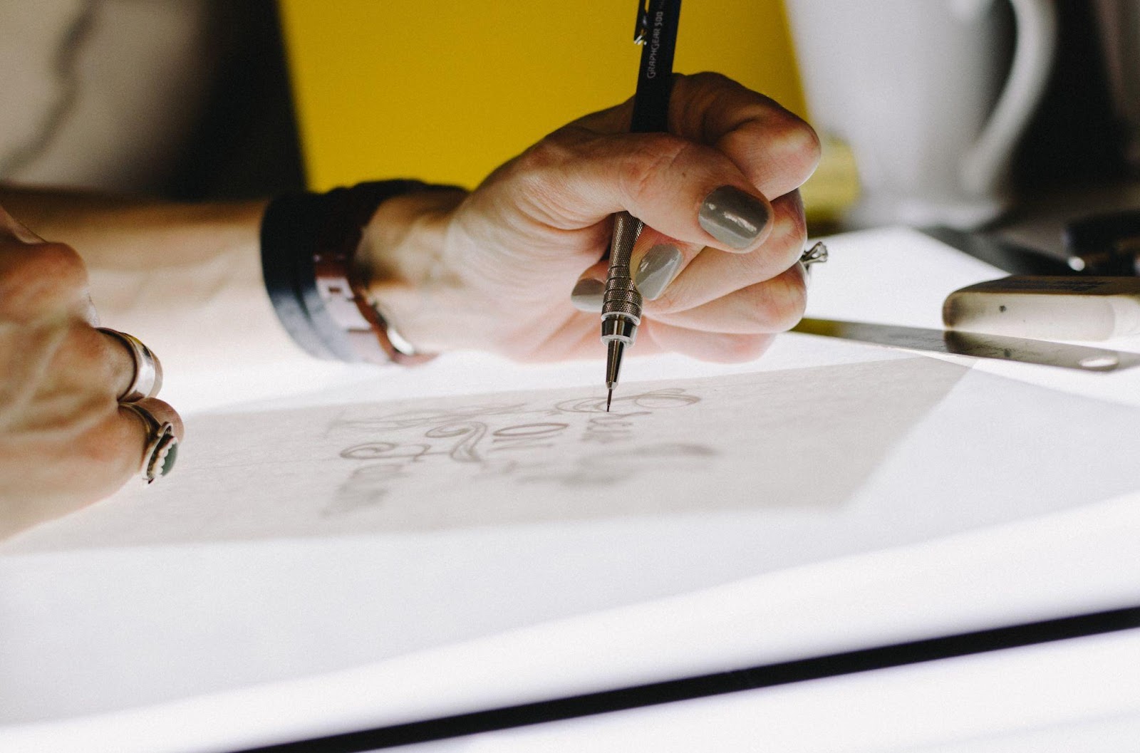 A picture of a person drawing design concepts on a table like Ann Dishinger does during her creative process.