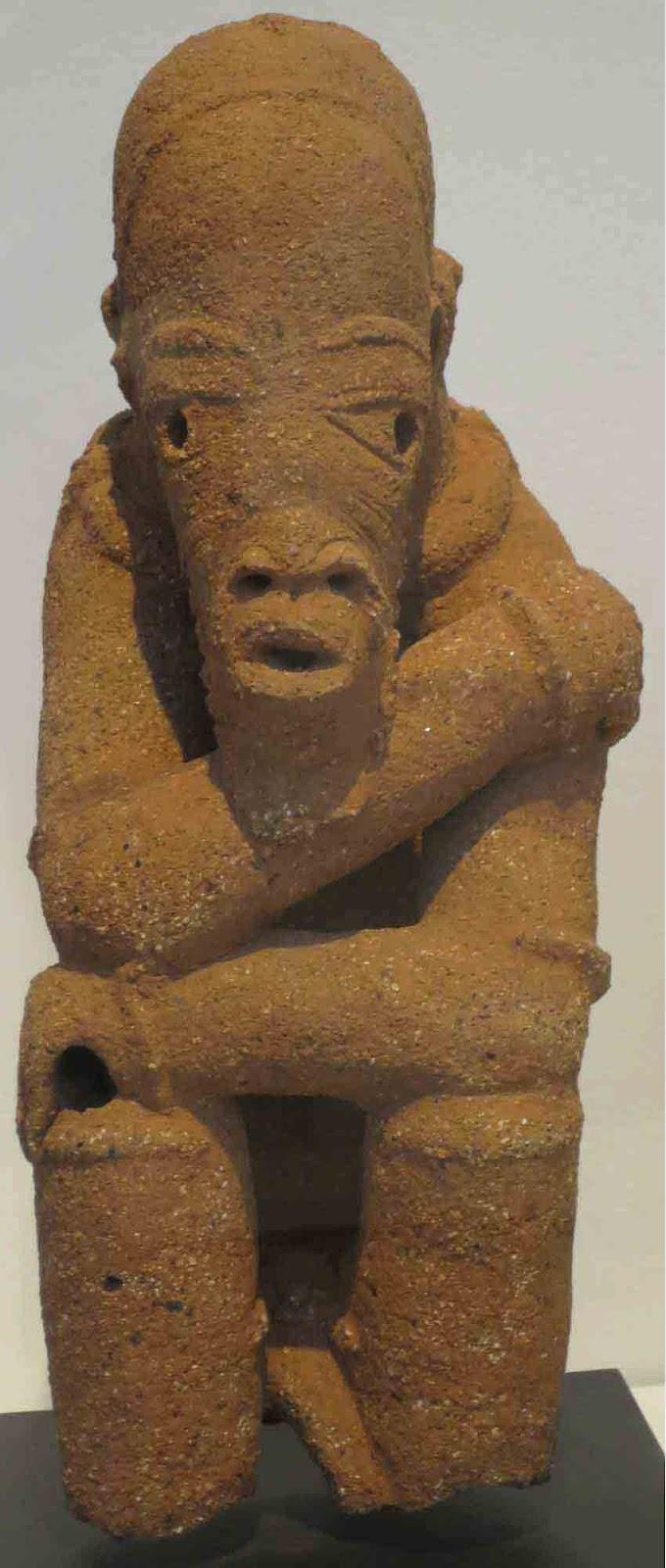 Kneeling figure from the Nok culture. Appears to be made from red sandstone.