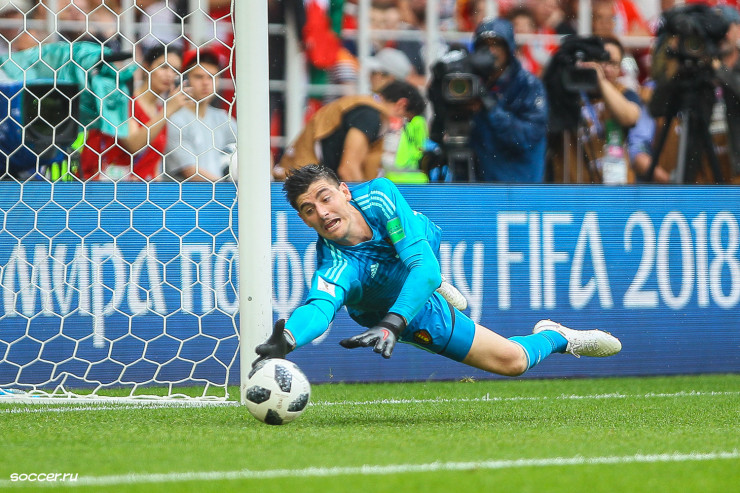 Tall soccer player - goalkeeper Courtois saving the ball 