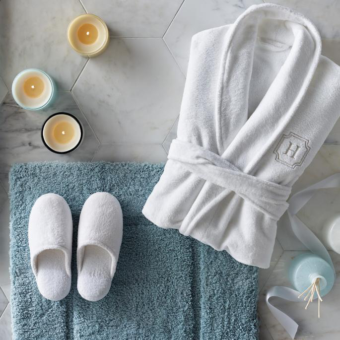 Set of hotel amenities (such as towels, shampoo, soap etc) on the bed. Hotel  amenities is something of a premium nature provided in addition to the room  when renting a room. Stock