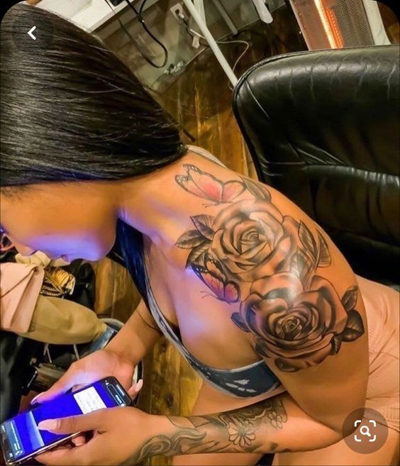 lady with a flower shoulder tattoo fiddling phone 