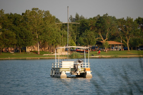 small sail boat on a lake without a sail