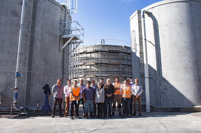 A group of people standing in front of a large concrete structure

Description automatically generated with low confidence
