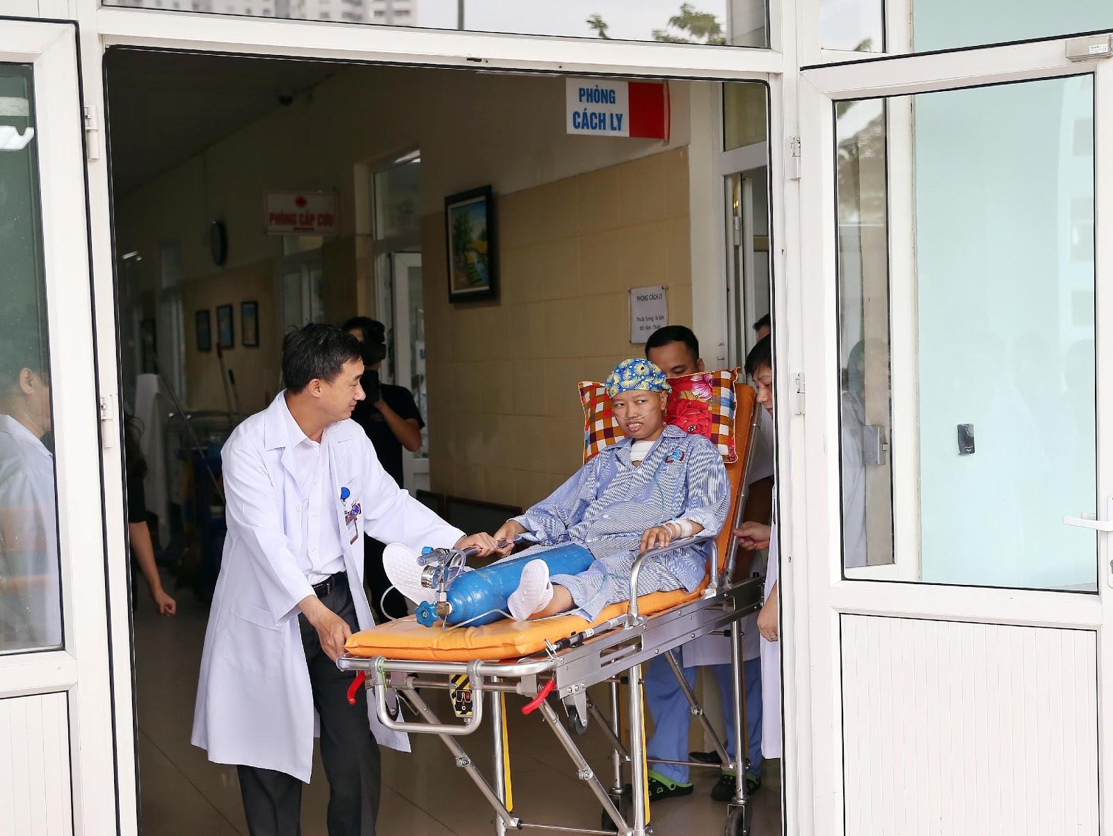 Chị Nguyễn Thị Liên được đưa từ phòng cách ly bệnh viện K Tân Triều ra xe cứu thương để di chuyển đến bệnh viện Phụ sản Trung ương thăm con trai. Ảnh: NVCC.