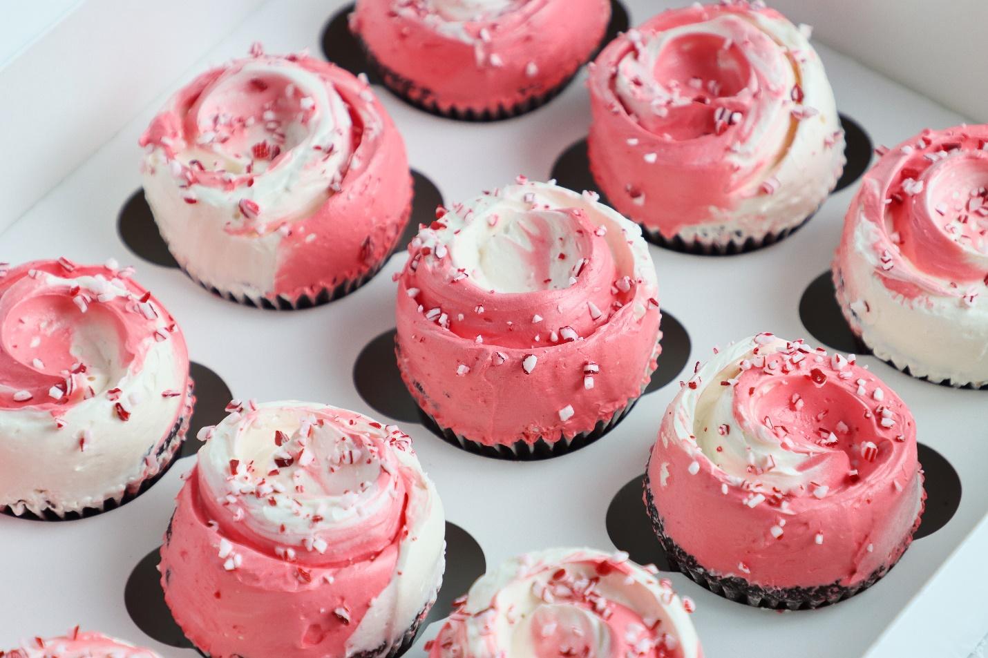 A group of cupcakes with pink frosting

Description automatically generated