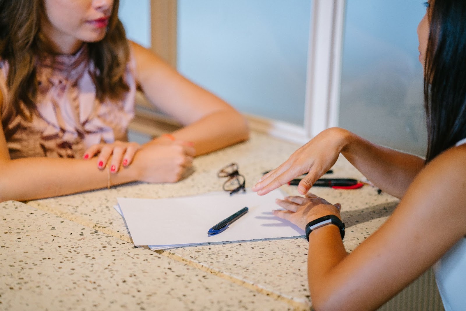 Women talking with a resume on the table How to Write a Great Resume
