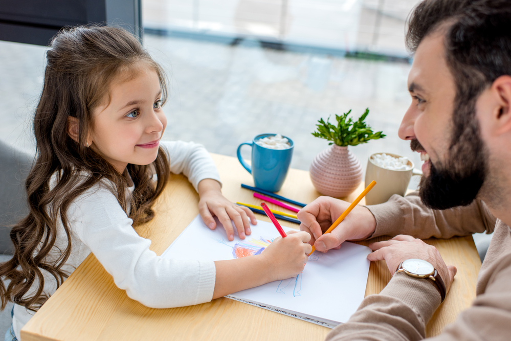 Dad working with daughter on sentences for kids 
