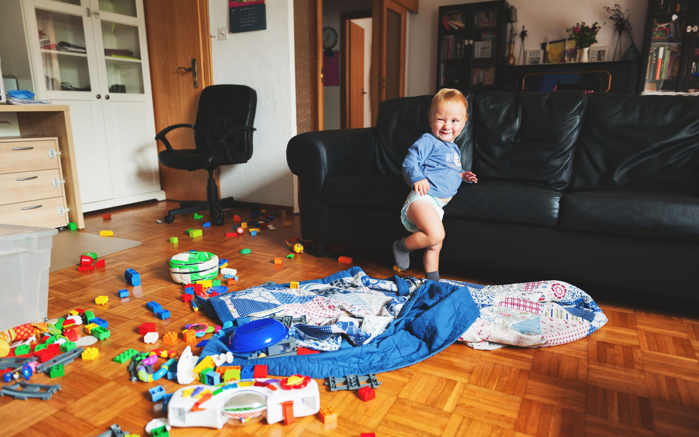 baby with scattered toys 
