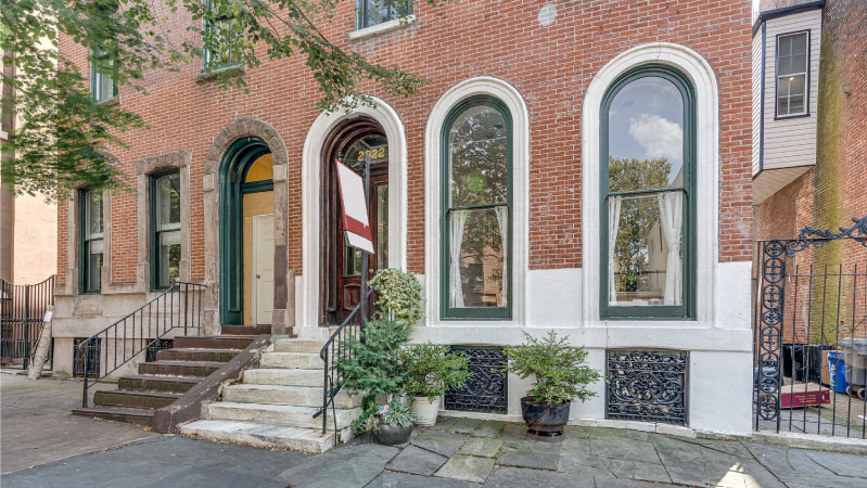 A brick condo building with ornate rounded windows and doorways in the Fairmount neighborhood of Philadelphia.