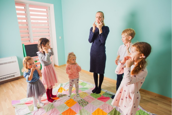 preschool teacher singing preschool songs with group of 5 children