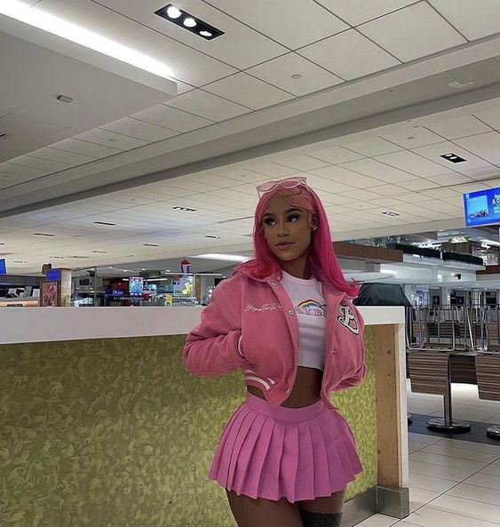 lady wearing pink sweat jacket with matching pleated micro mini skirt