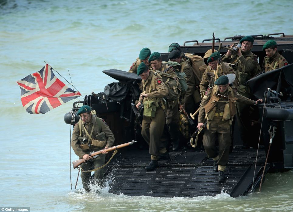 Action: Actors storm Gold Beach during a reenactment of the D Day landings - watched by the Duke and Duchess of Cambridge