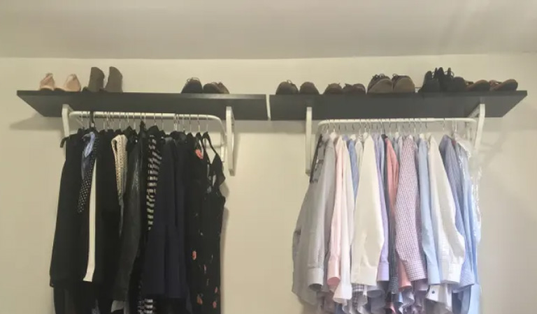 Ikea shelves with attached metal rails for shoe and clothing storage in a closet.
