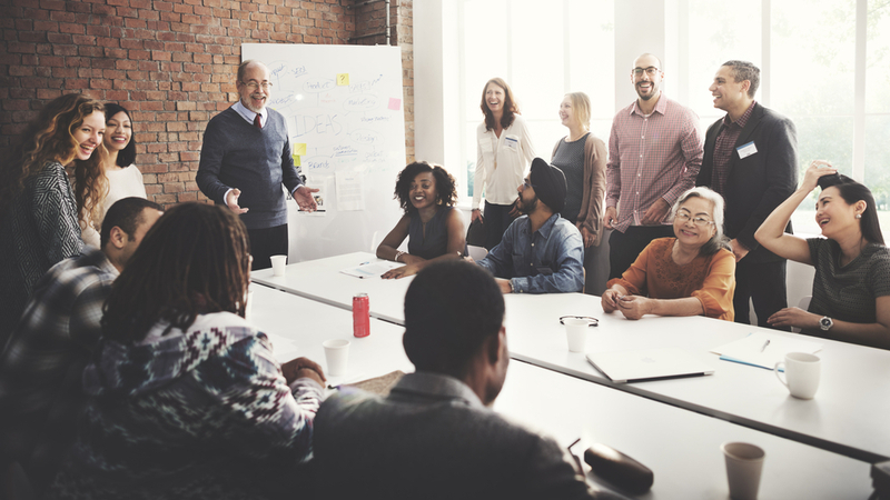 Senior man holding a business meeting in front of coworkers