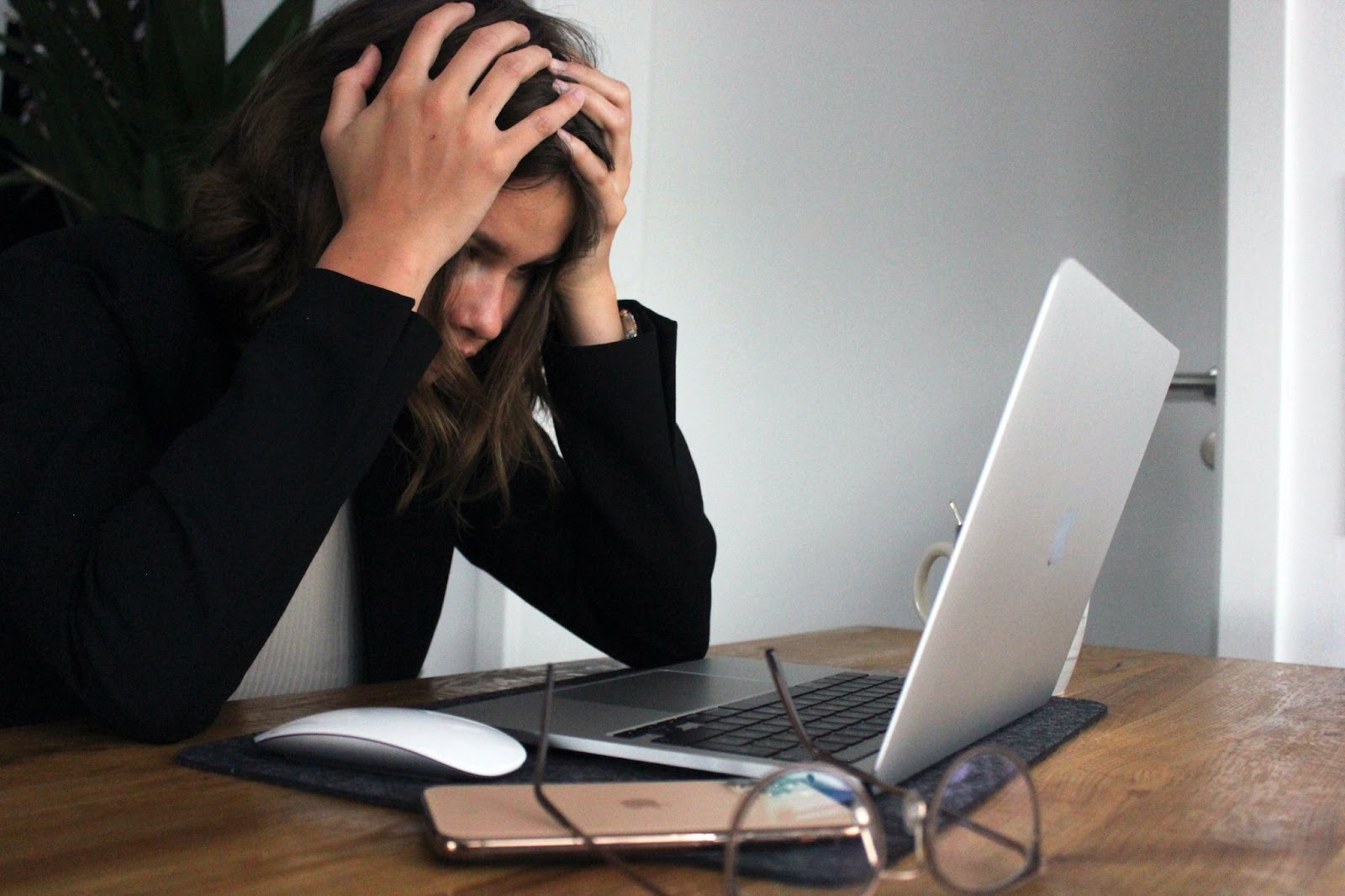 woman sitting at computer frustrated with her head in her hands