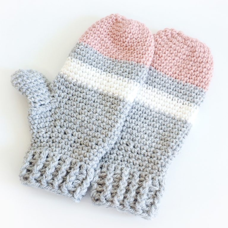 gray, white and pink crochet mittens on white background