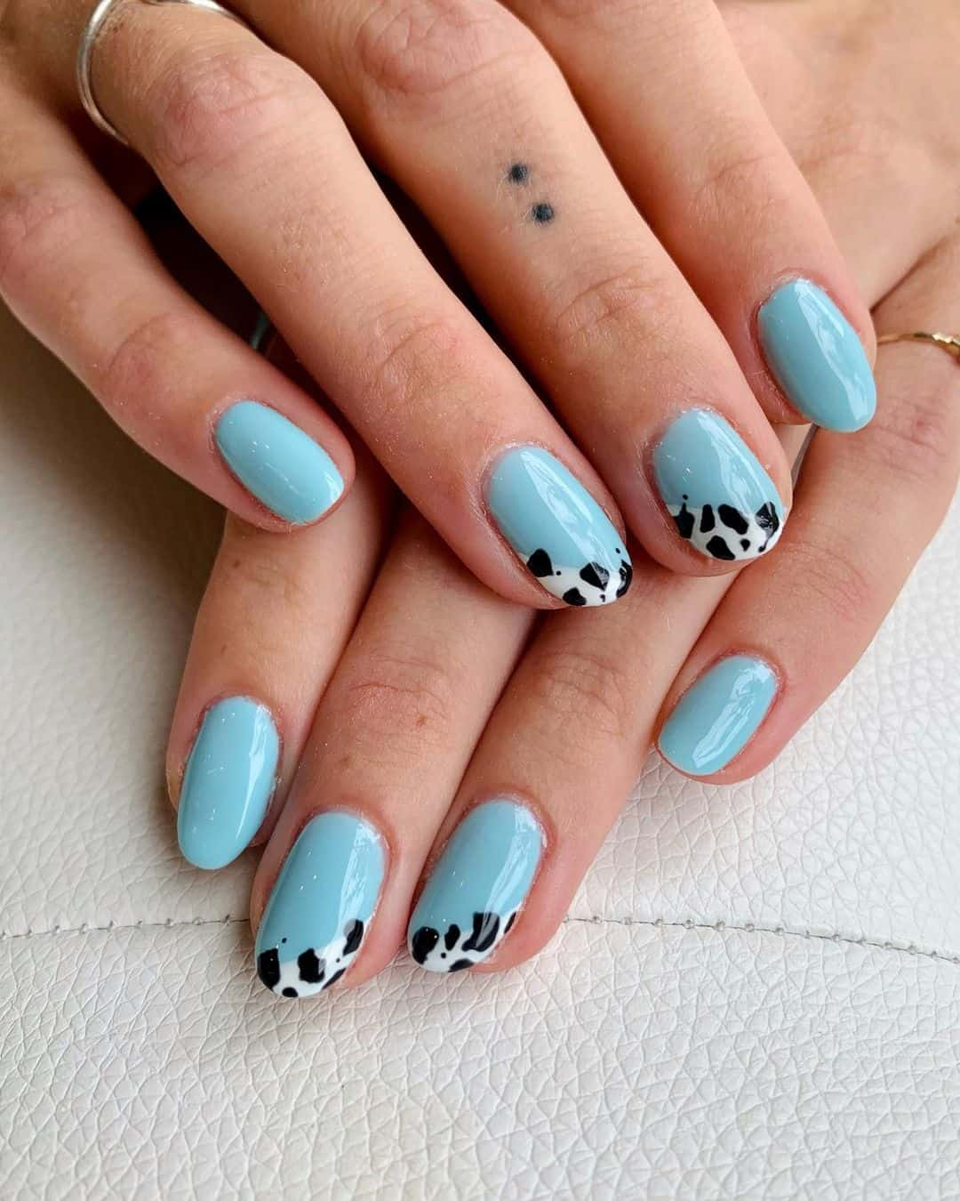 Short  blue  nails with cow print tips in the picture 