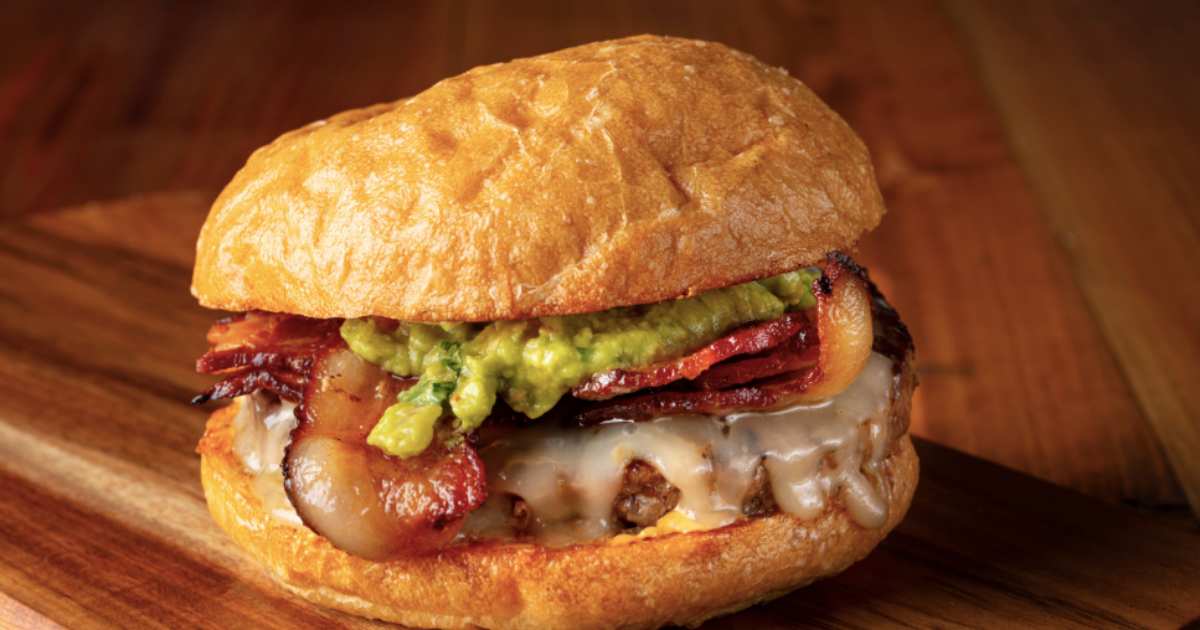 A gourmet guacamole burger with jack cheese and bacon.