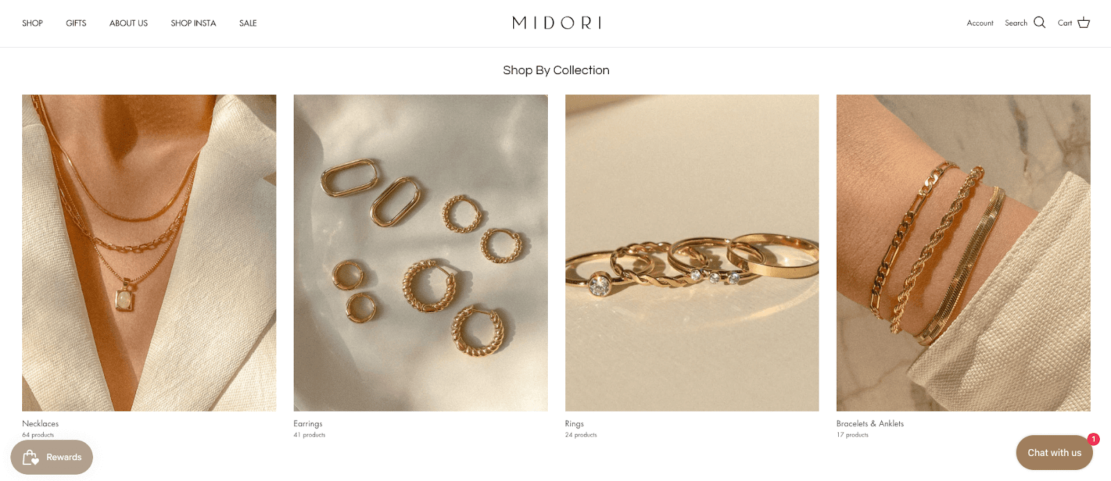 Valentine’s Day Gift Guide–A screenshot from Midori Jewelry Co.’s homepage showing their collections. The heading reads, “Shop by Collection”. Underneath there are 4 minimalist, product images of gold dainty jewelry representing their four collections: Necklaces, Earrings, Rings, Bracelets and Anklets. 