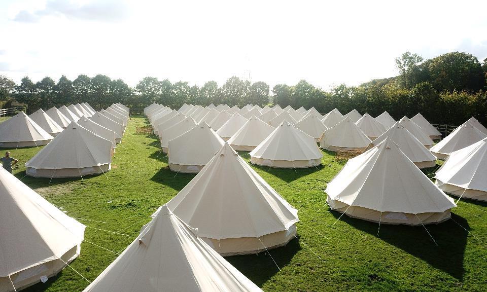 A group of white tents in a grassy field

Description automatically generated with low confidence