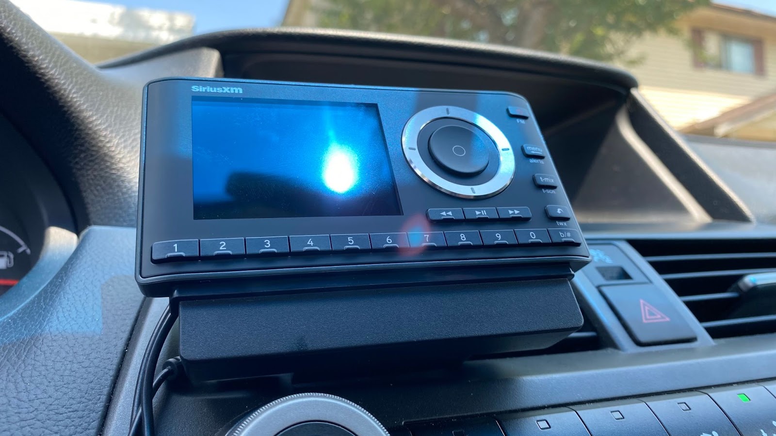 The Sirius XM Onyx Plus Satellite Radio docked in a car using the included vent mount.