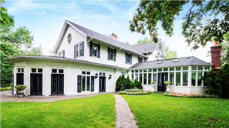 A sprawling two-story home in Riverside, IL. It’s painted white with plenty of windows and a sun room. 